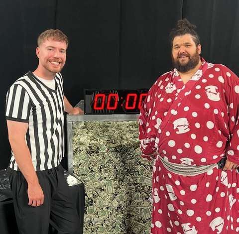 Ramy Elgazar in a polka dot robe with MrBeast in a referee shirt during a sumo challenge
