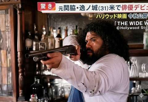 Ramy Elgazar aiming a pistol in a still from the feature film The Wide West